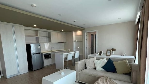 A modern apartment with a kitchen, dining area, and living room. - Seven Seas Condo Resort by PSR (Pattaya)