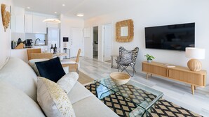 Una sala de estar moderna con un sofá, una mesa de centro y un televisor.