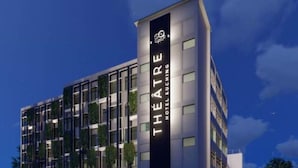 Un hotel moderno con un llamativo letrero vertical que dice "THEATRE HOTEL KUCHING".