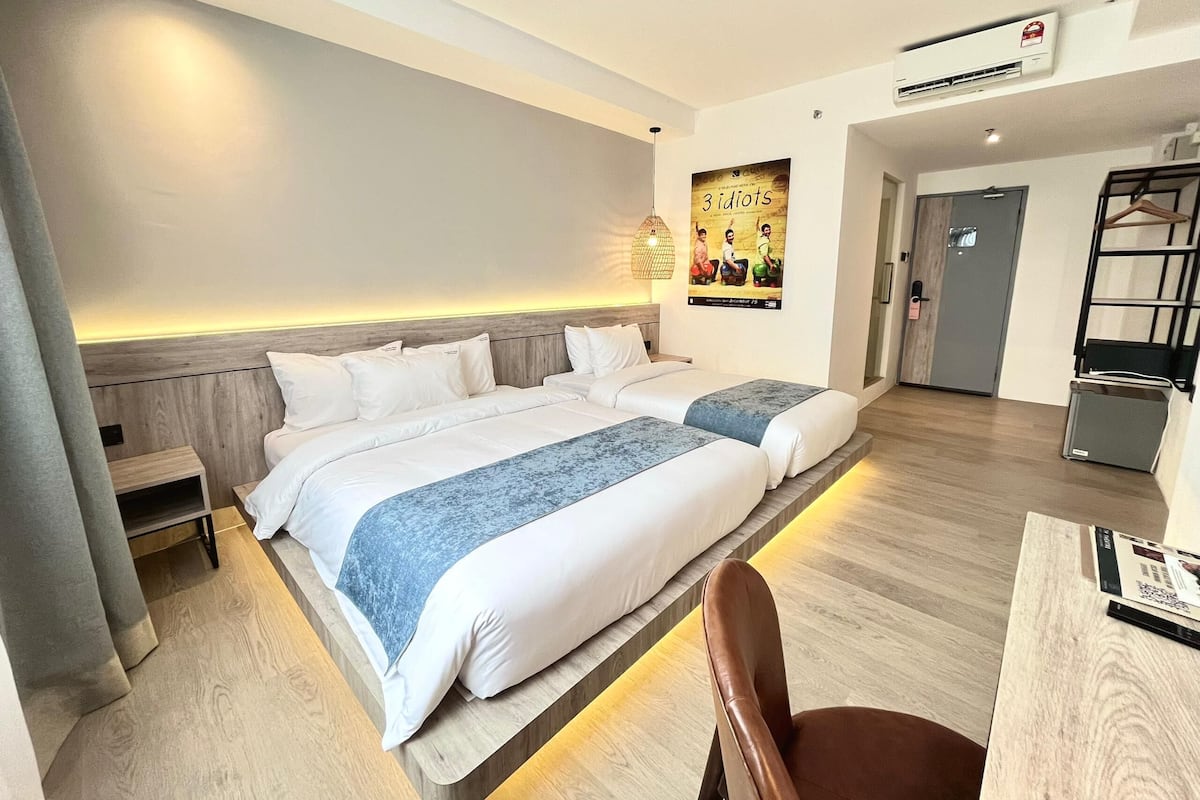 A hotel room with a large bed, bedside tables, a desk, and a chair.