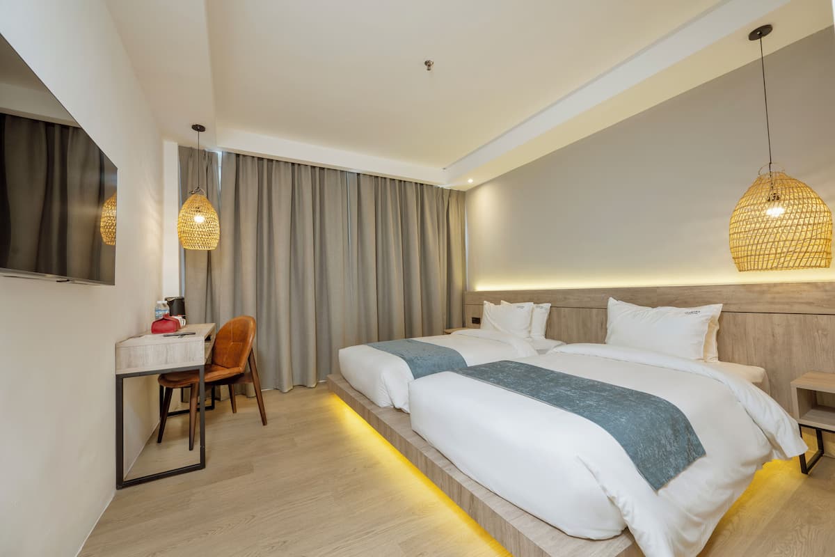 A modern hotel room with a large bed, a desk, and a chair.