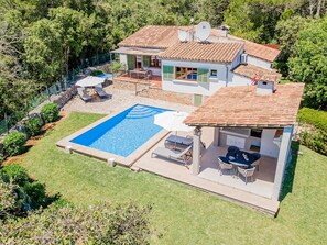 A two-story house with a swimming pool, outdoor seating, and a stone wall. - Villa Can Bon Jesus by SunVillas Mallorca (Pollença)