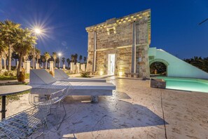 A stone building with a door, surrounded by palm trees and a pool. - Villa Turris - Alliste ,Apulia (Alliste)