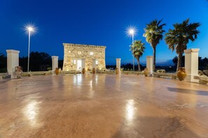 A stone building with columns, palm trees, and vases in an open area. - Villa Turris - Alliste ,Apulia (Alliste)