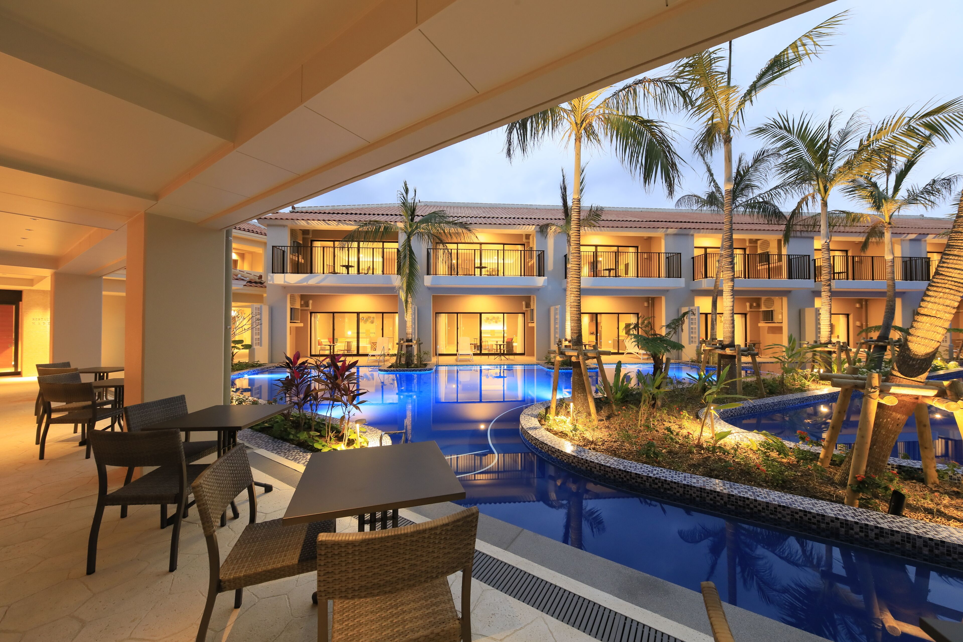 A hotel pool area with lounge chairs and a pool.