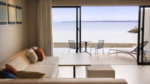 A modern living room with a sofa, a coffee table, and a balcony with a view of the sea. - VIVOVIVA ISHIGAKIJIMA (Ishigaki)