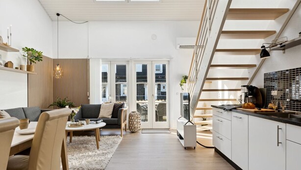 Ein modernes Interieur mit Wohnbereich, Küche und Treppe.