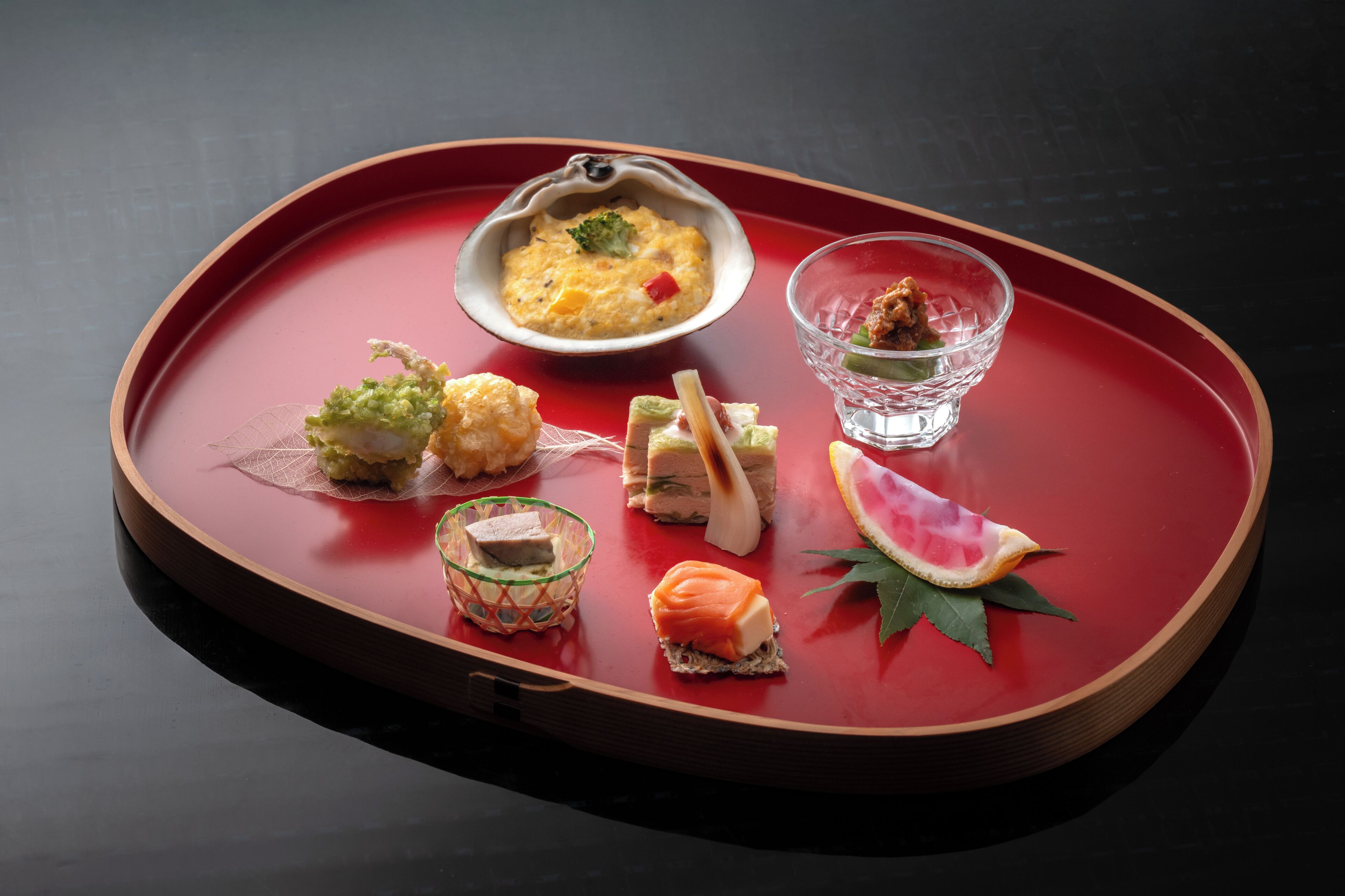 A tray with various food items including a bowl of soup, a glass of drink, and several small dishes with different foods.