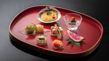 A tray with various food items including a bowl of soup, a glass of drink, and several small dishes with different foods.