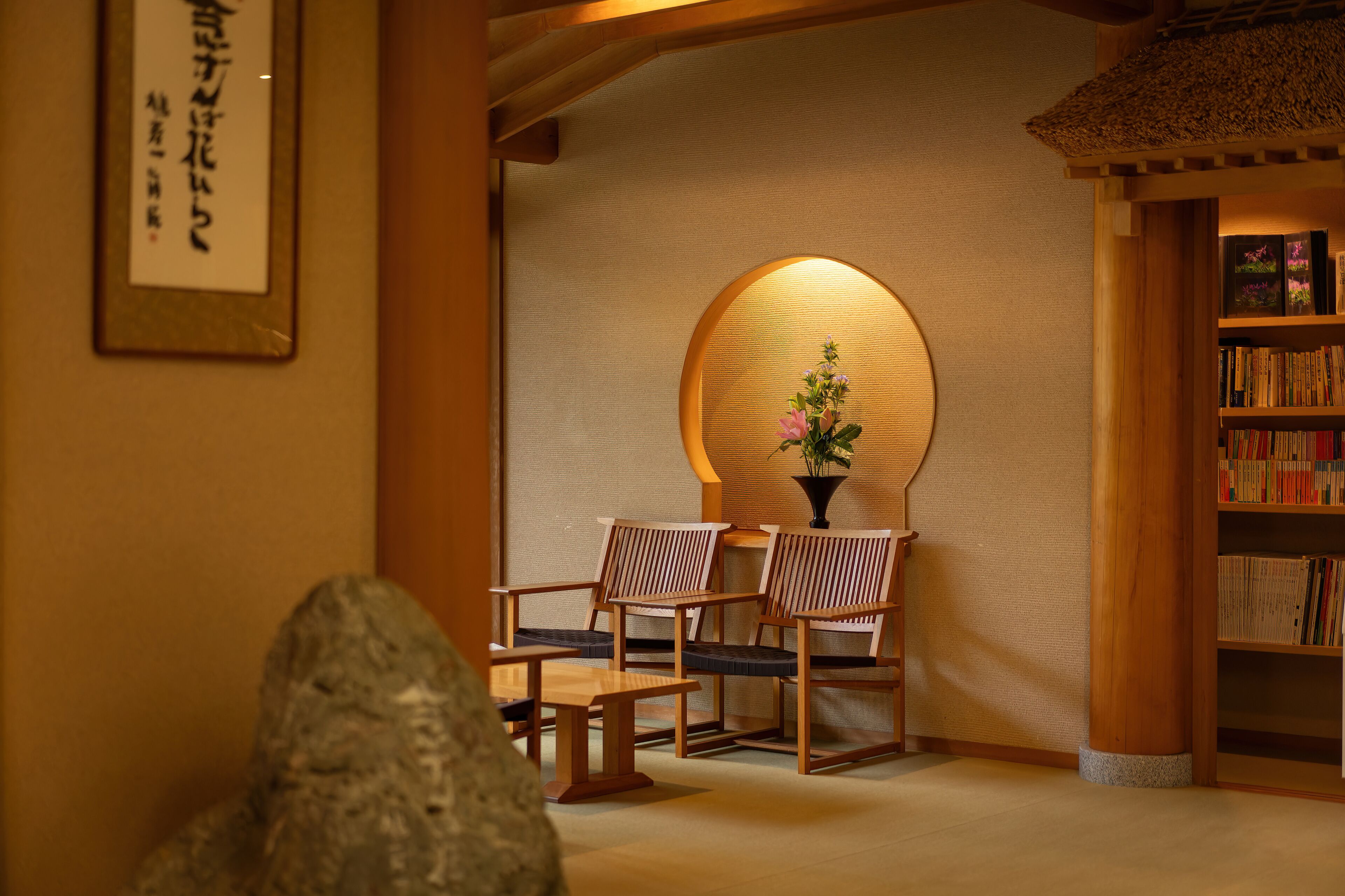 A traditional Japanese interior with tatami mats, wooden furniture, and a bookshelf.