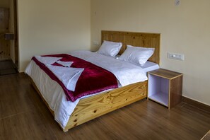 Cozy retreat with a wooden bed frame, nightstand, and white linens.