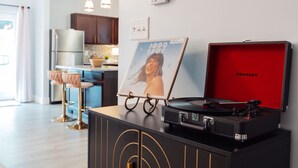 Una cocina moderna con refrigerador empotrado, armarios de madera e iluminación colgante.