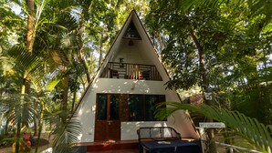 A triangular-shaped building with a balcony, surrounded by lush greenery. - Feather Touch Hotels and Resorts Palolem (Canacona)