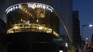 Un edificio moderno con fachada curva y señalización iluminada.