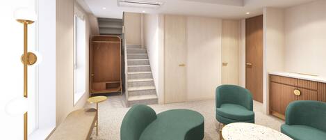 A modern interior with a curved sofa, a small round table, and a staircase leading to a closet.