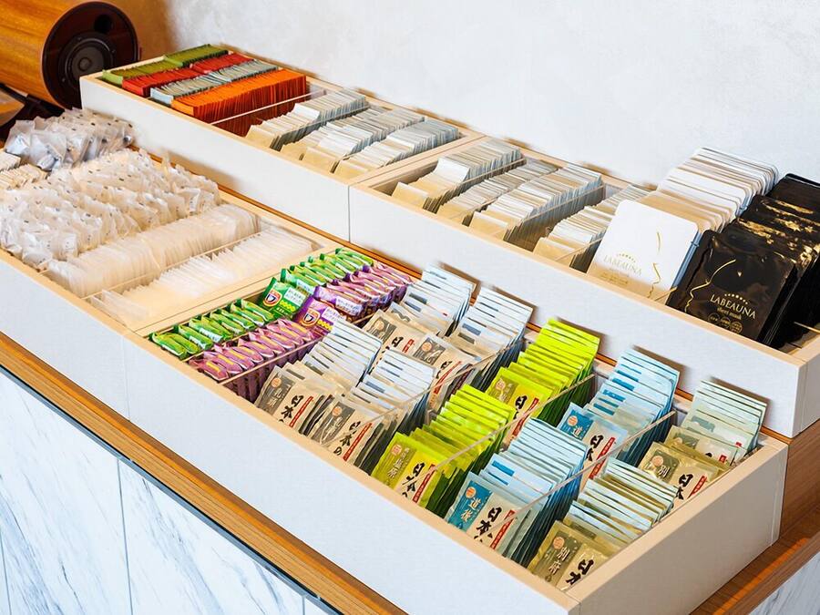 A display of various packaged goods, including food items and possibly cosmetics, arranged in a wooden drawer.