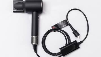A black microphone with a cable and a power adapter.