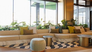 Un vestíbulo moderno con un amplio espacio de asientos, una mesa de centro y una planta en maceta.