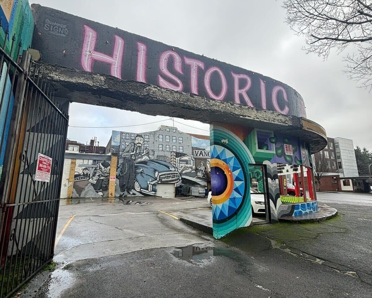 An entrance with a 'HISTORIC' sign, a mural, and a colorful kiosk.
