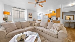 A modern living room with a beige sectional sofa, a coffee table, and a ceiling fan. - #StayInMyDistrict Downtown Loft2 (Vancouver)