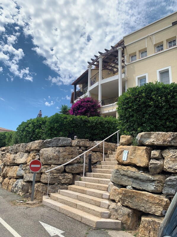 A stone staircase leading to a building with a balcony, a no entry sign, and a sign indicating the building is for sale. - Cap Estérel FH Grand T2 Jardin Clôturé /clim /parking Couvert /piscines/ vue Mer (Saint-Raphaël)