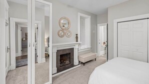 A bedroom with a fireplace, a bed, and a ceiling fan. - Walk to Forest Park | Fire Pit & Porch Swing (St. Louis)