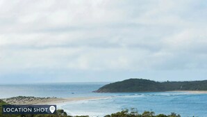 A coastal landscape with a beach, ocean, and a hill in the distance. - Aloha Beach House – downstairs suite, close to beach (Fingal Bay)