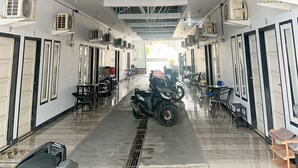 Um corredor com aparelhos de ar condicionado, uma motocicleta e áreas de estar.