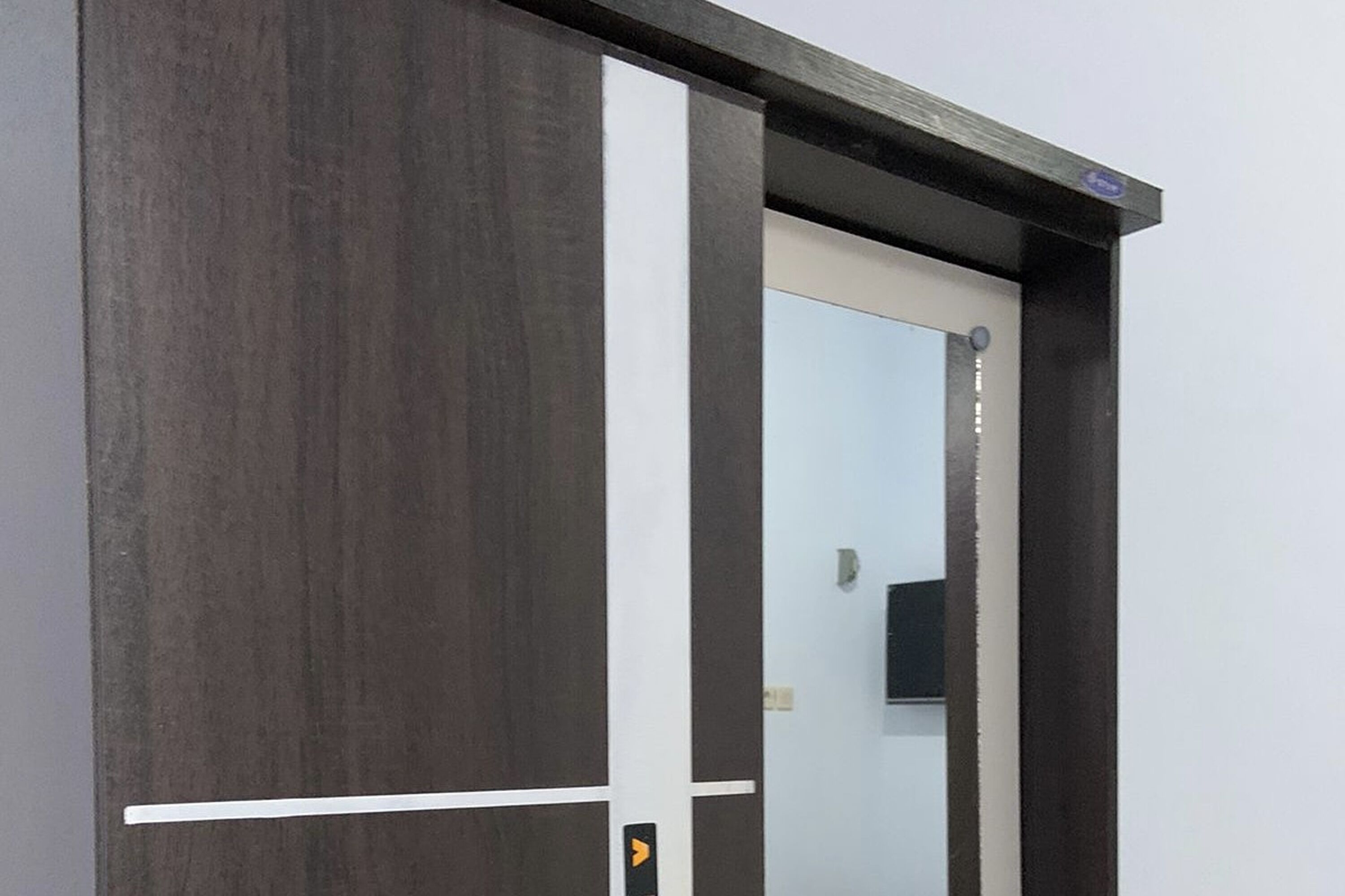 A modern door with a dark wood finish and a white frame.