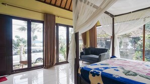 A room with a bed, a chair, and large windows with curtains. - Baruna Lakeside View (Kintamani)