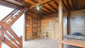 A wooden interior with a bench, a chair, and a wooden door. - Baruna Lakeside View (Kintamani)