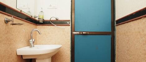 Un baño pequeño con un lavabo blanco, un espejo y una puerta azul.