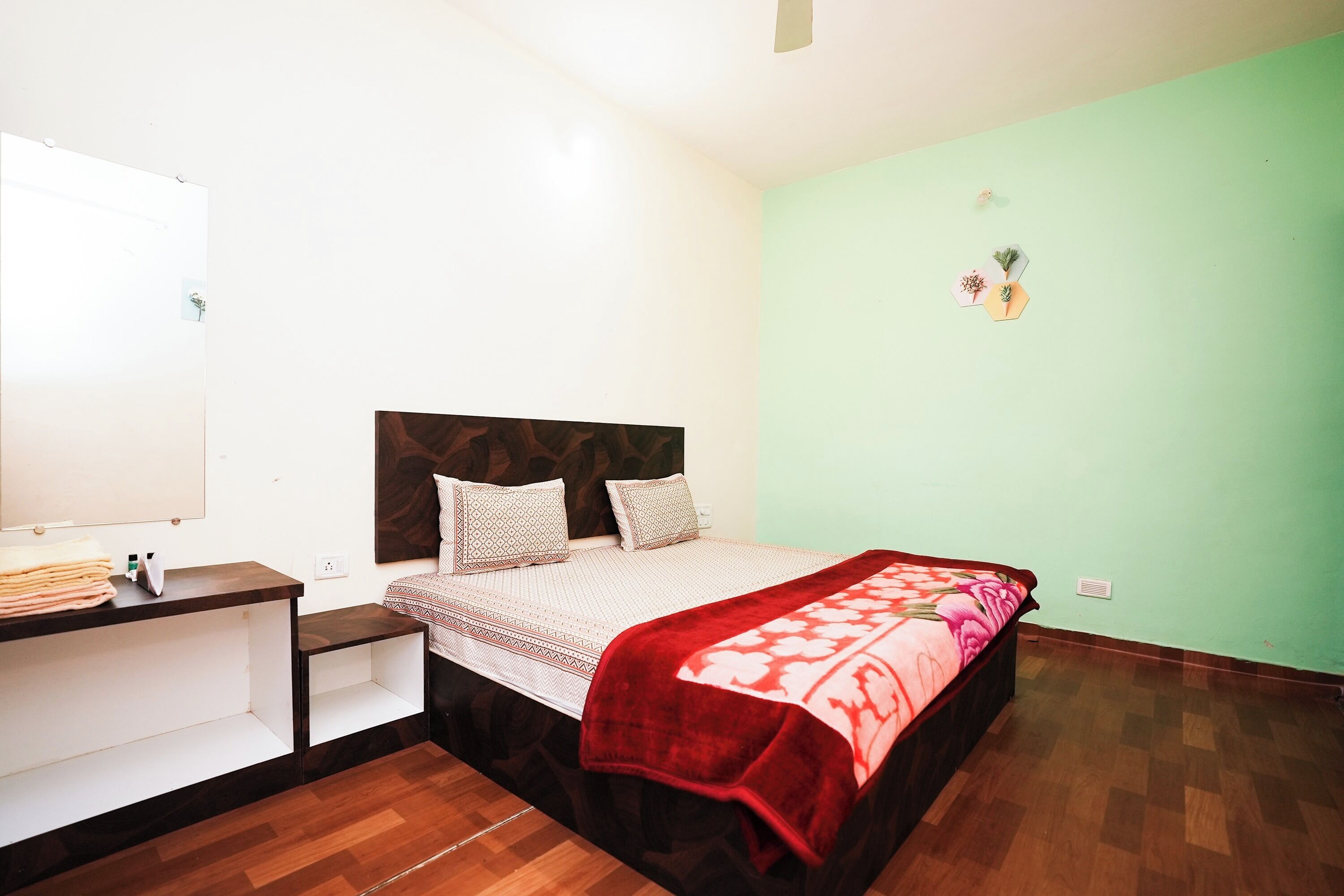 A bedroom with a bed, bedside table, and a small desk.