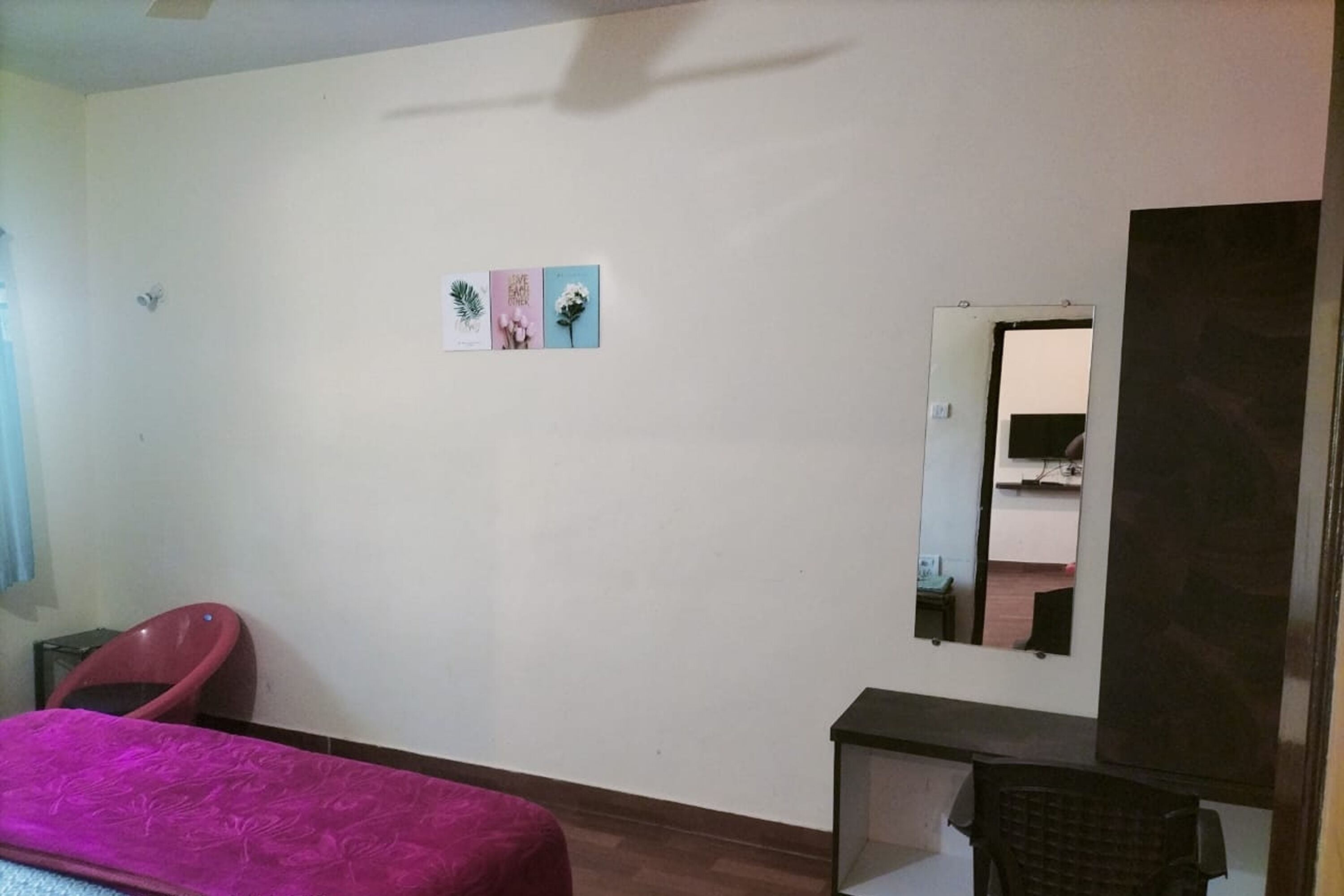 Une chambre à coucher avec un lit, un bureau, une chaise et un miroir.
