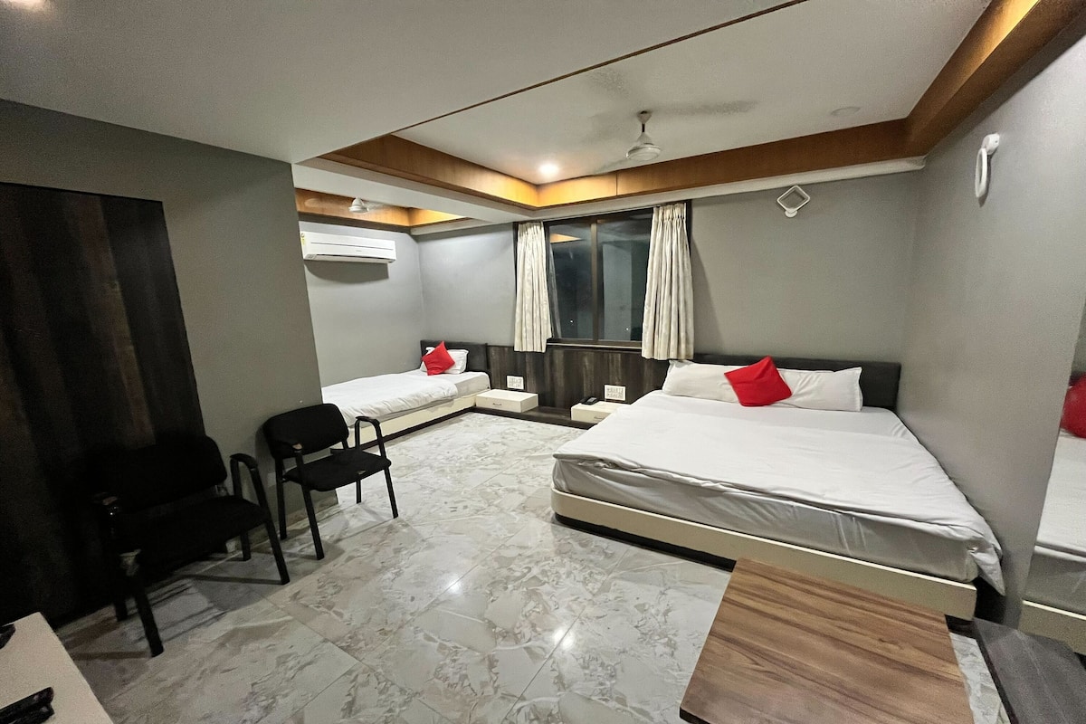 A modern hotel room with two single beds, a desk, and a chair.