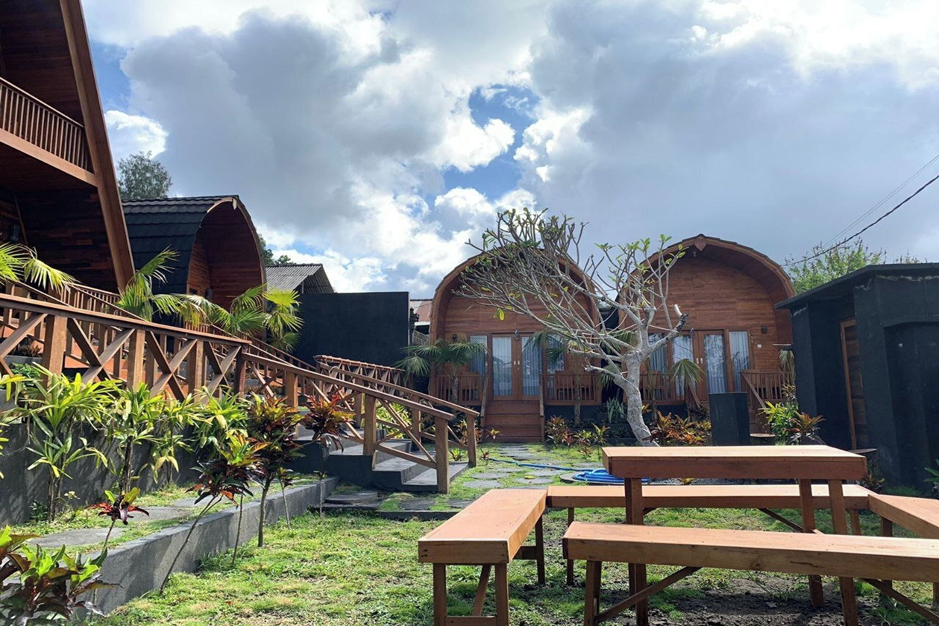 A wooden cabin with a covered patio, outdoor seating, and a small garden area.