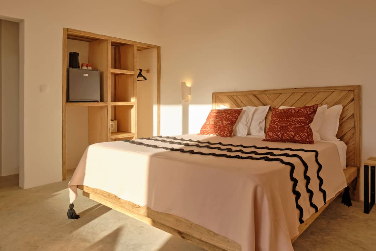 A bedroom with a wooden bed frame, a built-in wardrobe, and a bedside table.