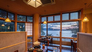 Un comedor tradicional japonés con esteras de tatami, mesas bajas y puertas correderas shoji.