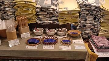 A display of folded fabrics and baskets with labels, likely in a fabric store.