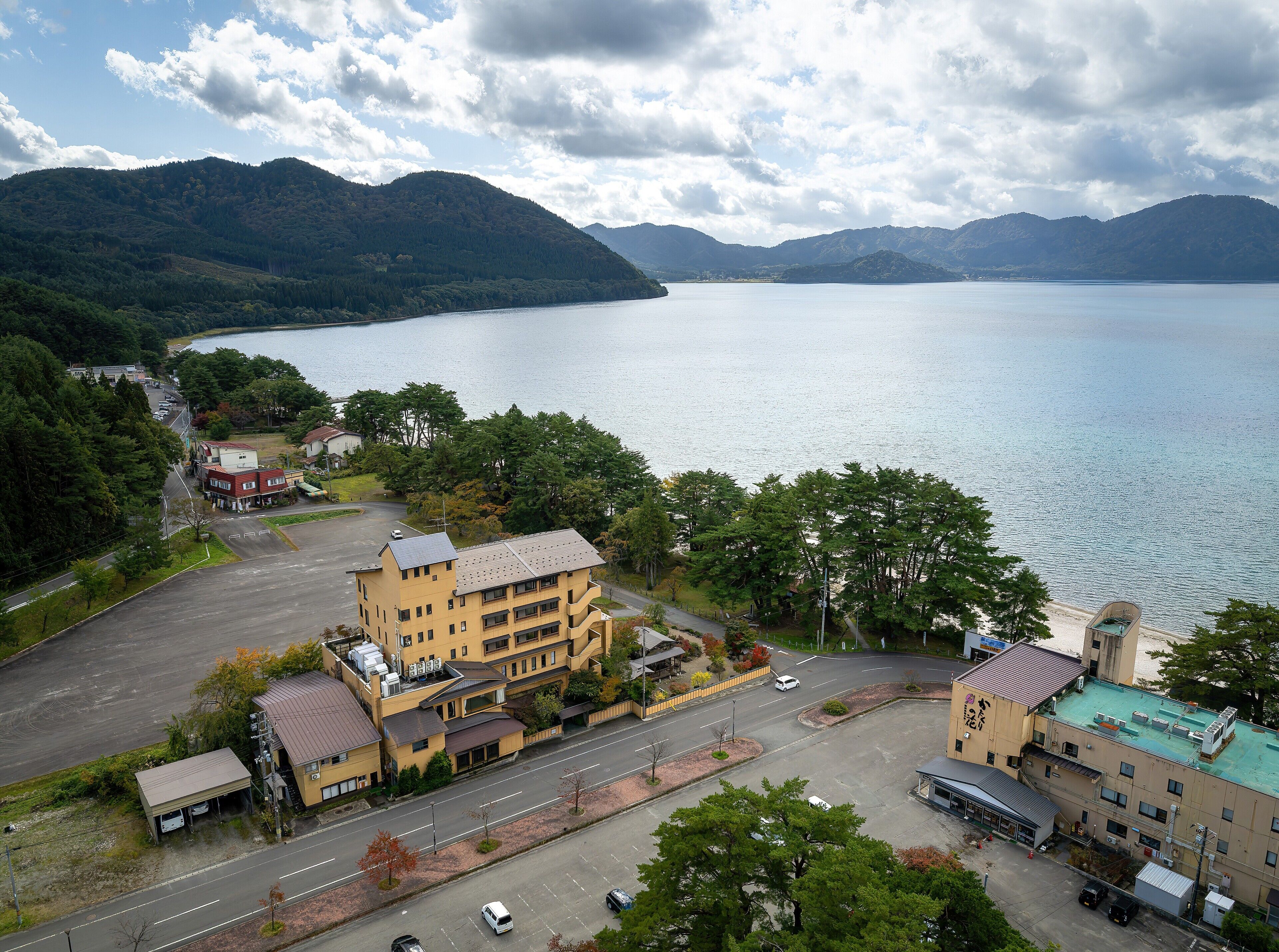 Un immeuble à étages, un parking et une vue sur un lac.