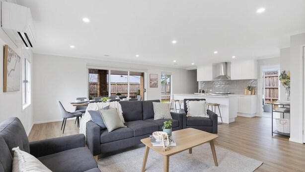 A modern living room with a grey sofa, a wooden coffee table, and a dining area with a table and chairs. - Salt Breeze in Cowes (Cowes)