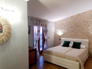 Panorama driepersoonskamer | Donsdekens, een bureau, een strijkplank/strijkijzer