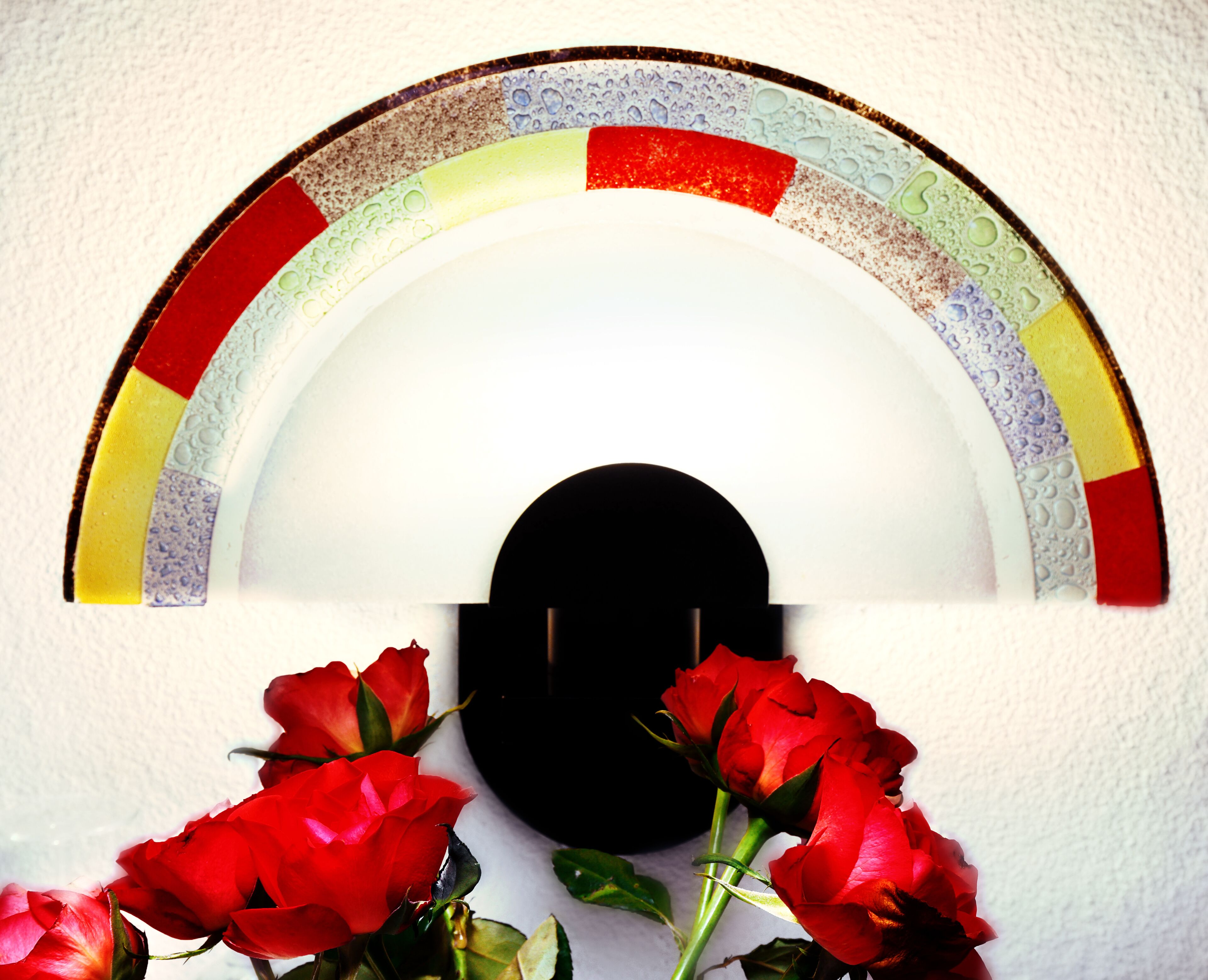 A white wall with a decorative arch and a black silhouette.