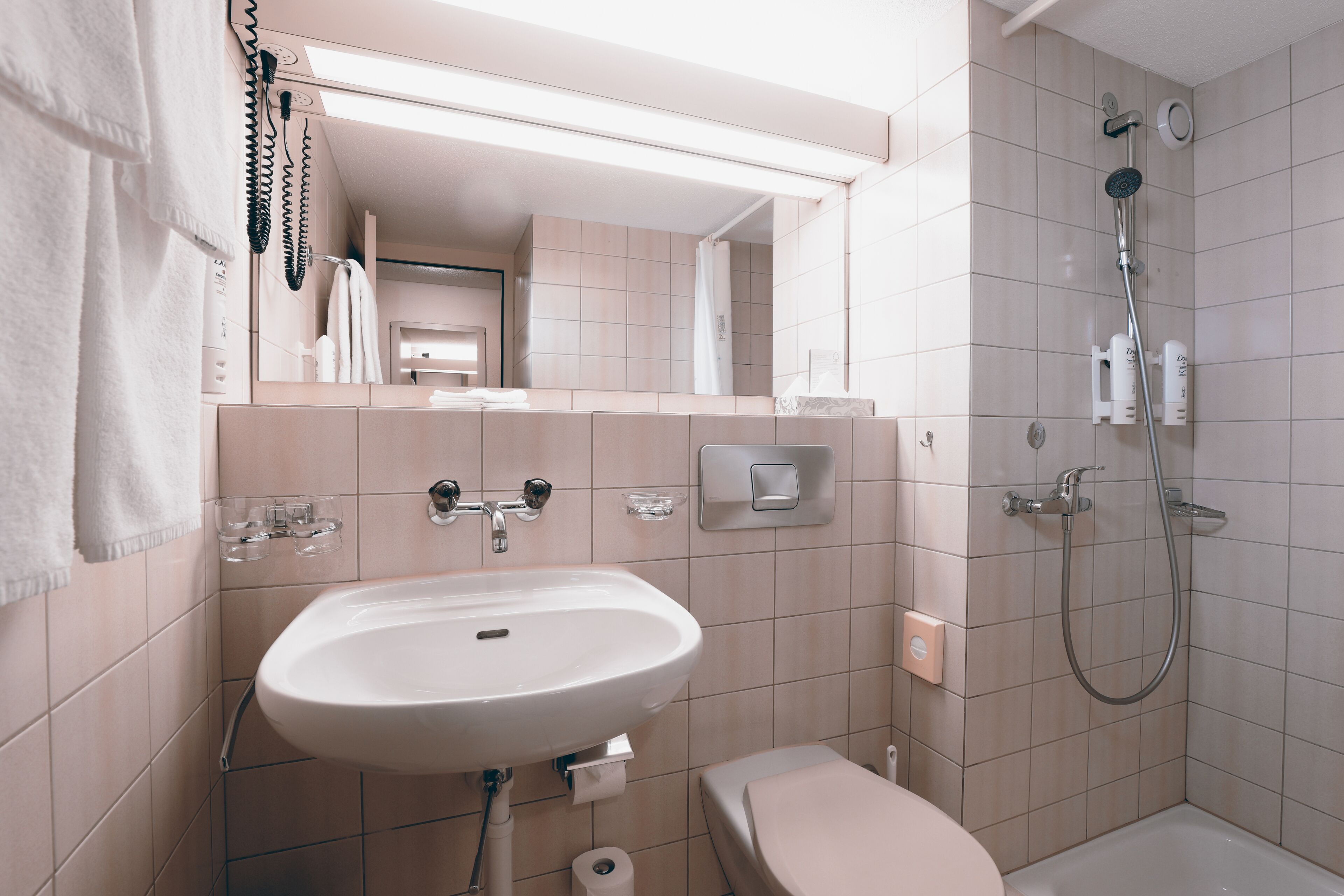 A bathroom with a sink, toilet, and shower.