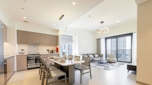 Eine moderne Küche mit Essbereich, großen Fenstern und einem Wohnbereich mit Sofa und Couchtisch.