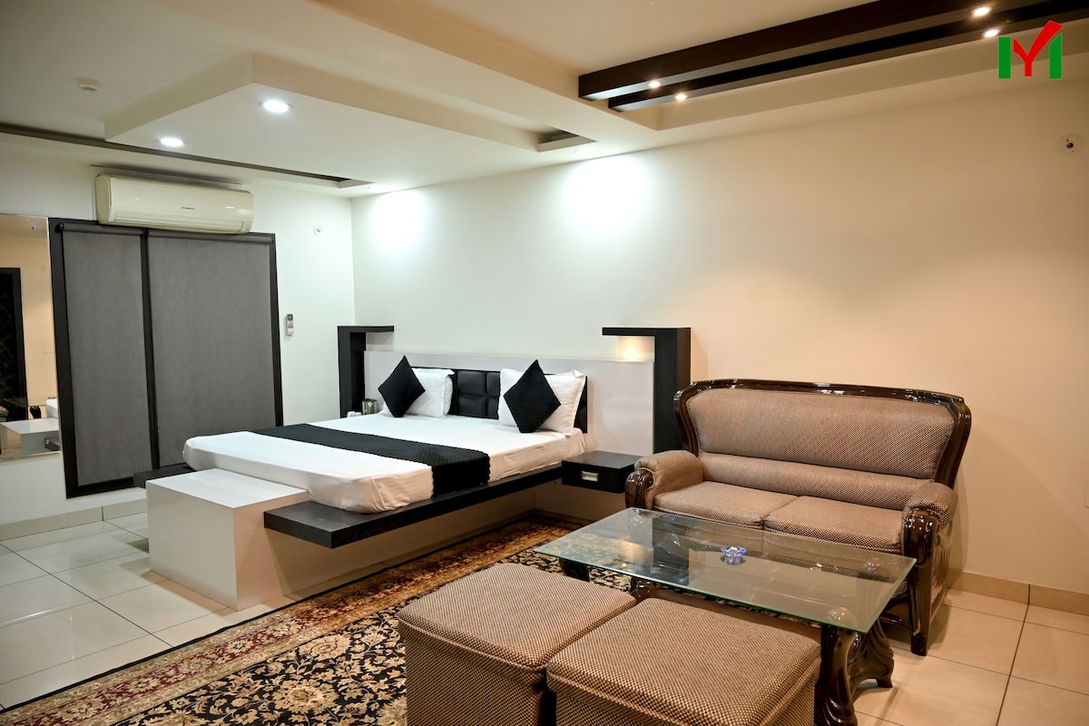 A modern bedroom with a bed, sofa, and glass coffee table.
