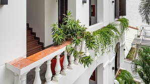 A multi-story building with white exterior walls, a balcony with potted plants, and a staircase. - 5H Garden  (Ho Chi Minh City)