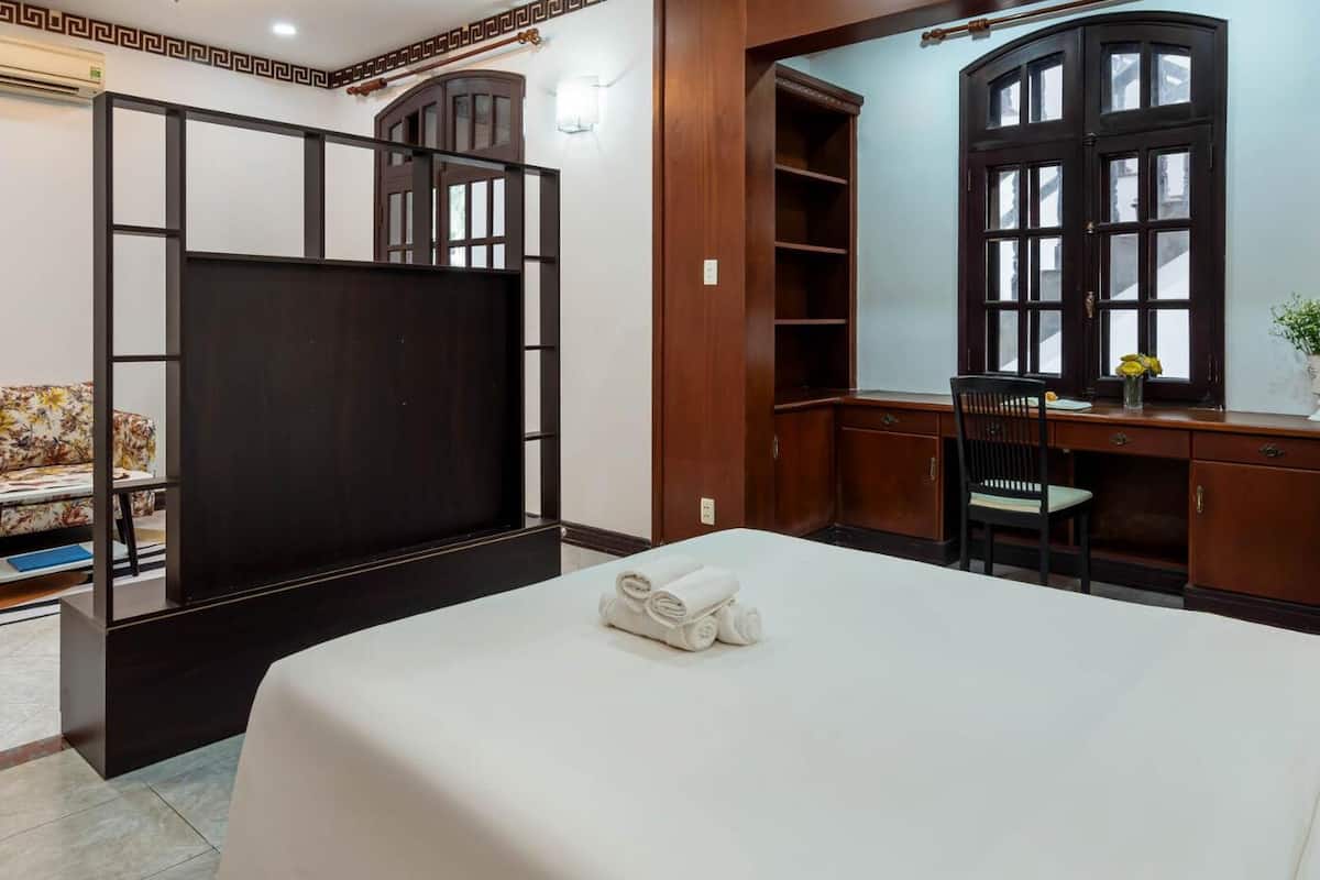 Une chambre d’hôtel comprenant un lit, un bureau, une chaise, un canapé et une armoire.