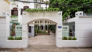 A gated entrance with a white archway, a small garden area with potted plants, and a sign indicating the gate number. - 5H Garden  (Ho Chi Minh City)