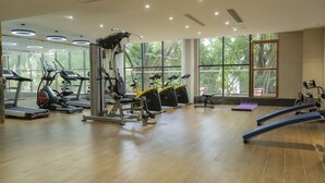 A gym with treadmills, elliptical machines, and weight equipment. - FM HOTELS (Abidjan)
